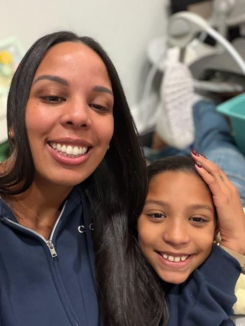 An adult and a child smiling together in a classroom