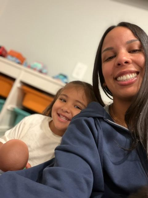 An adult and a young child smiling together in a classroom