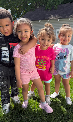 Four children together on the lawn outside