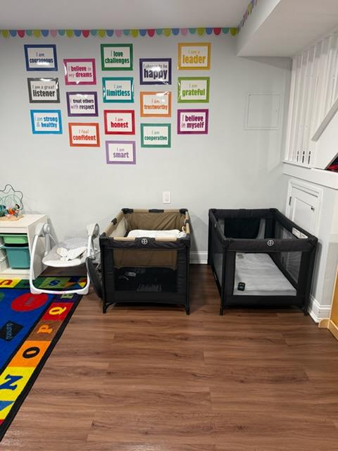 Nap area with portable cribs and affirmation posters