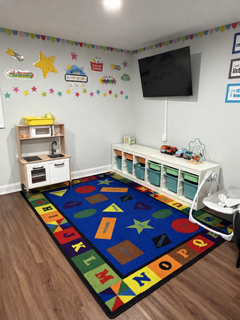 Playroom corner with a toy kitchen and alphabet rug
