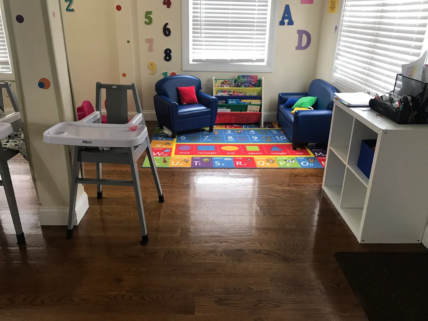 Indoor playroom with alphabet rug and blue chairs